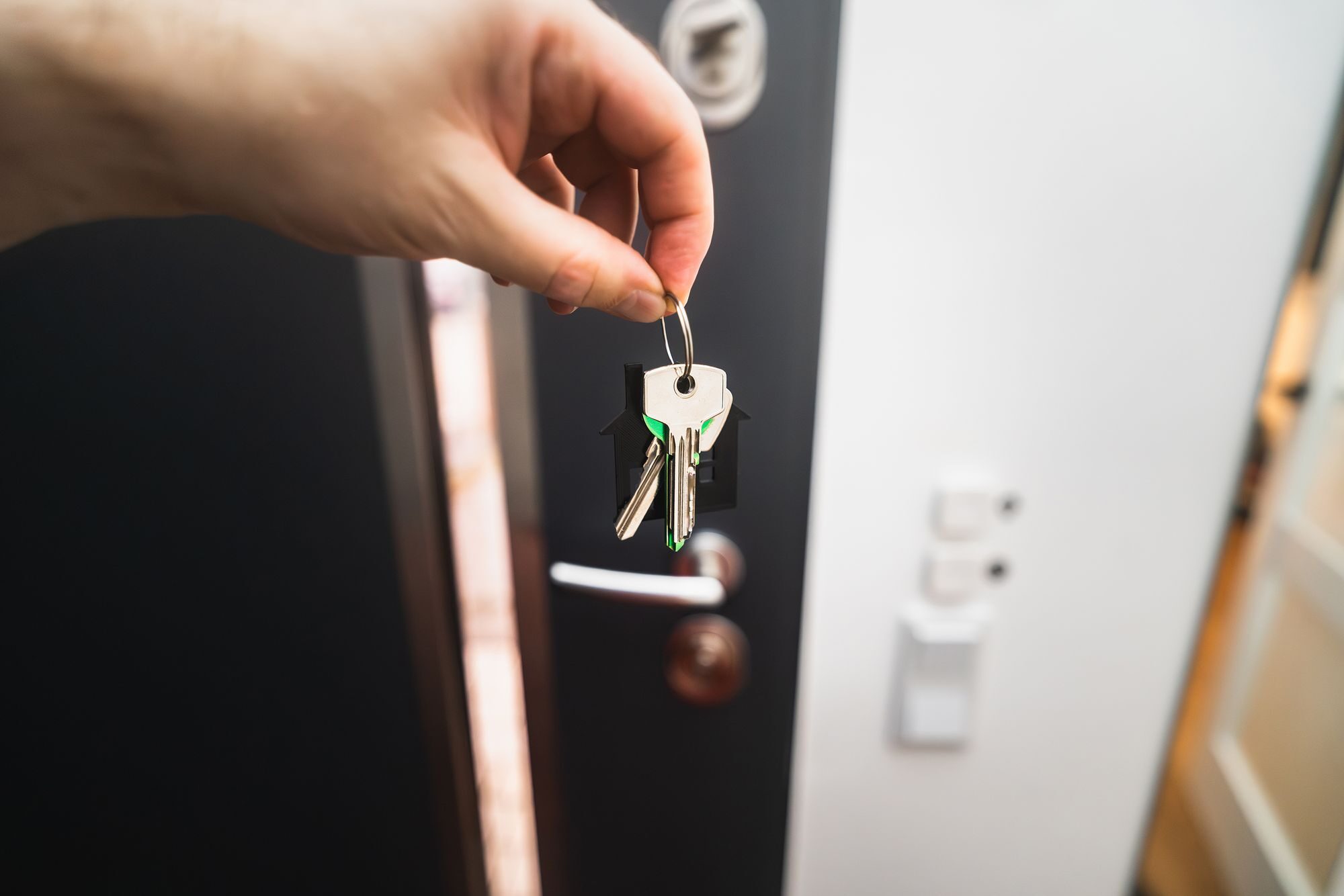 A hand holding the keys to a new home