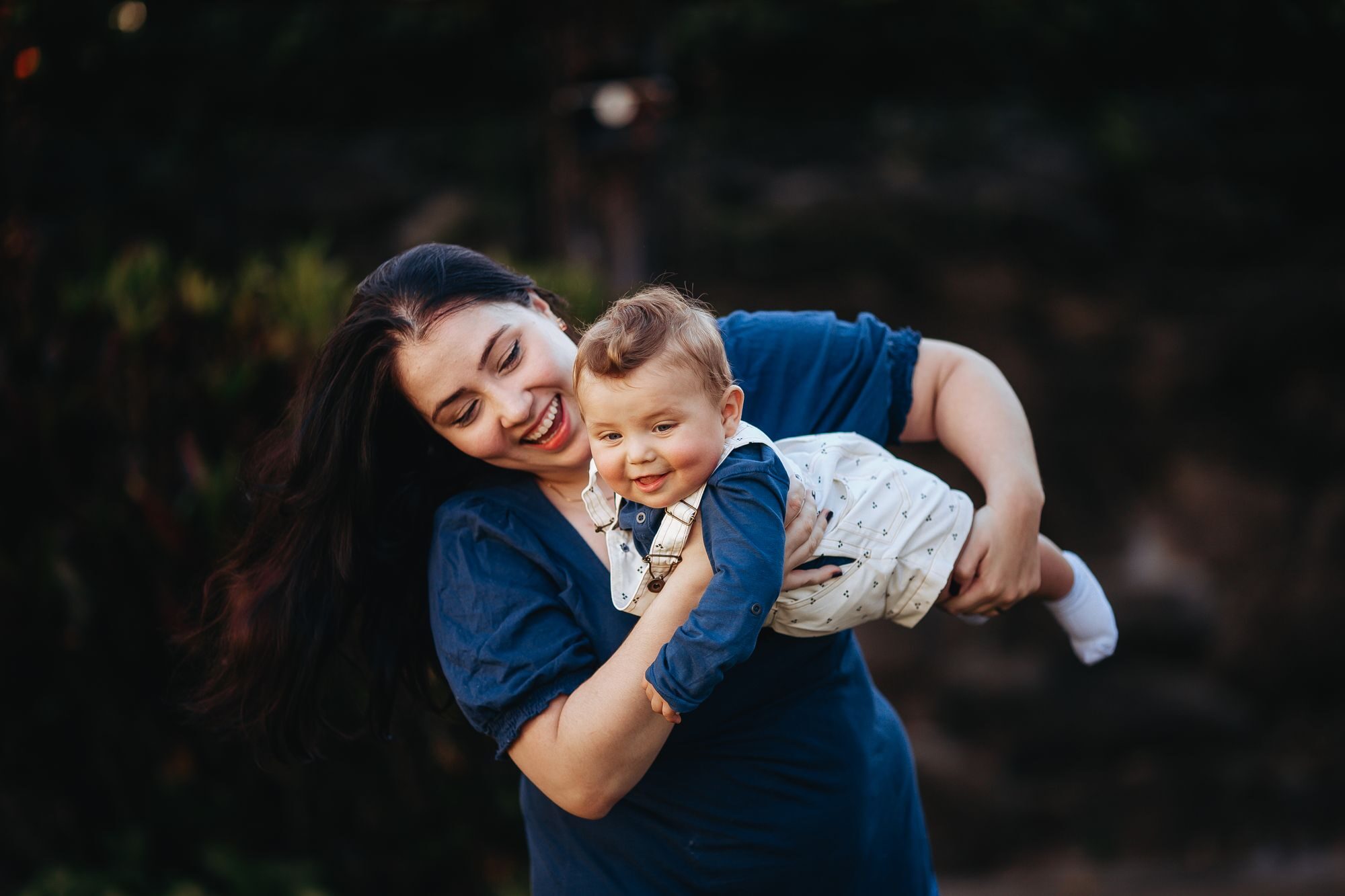 A mother holding her baby in warm, golden light