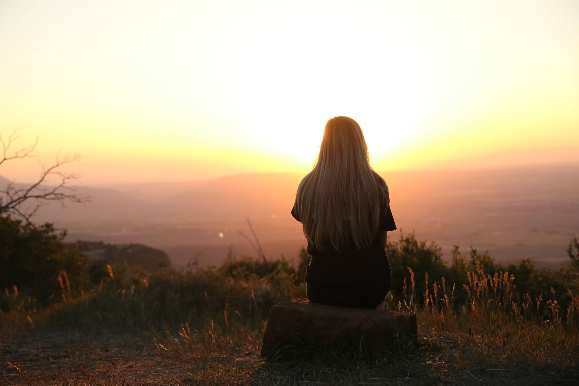 A woman looking toward a hopeful horizon at first light